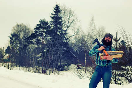 bearded handsome man went into the forest with an ax to produce wood for the furnaceの写真素材