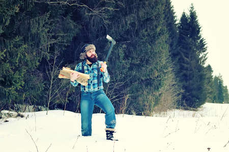 bearded handsome man went into the forest with an ax to produce wood for the furnaceの写真素材