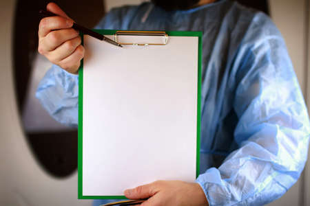 Doctor in blue robe holding a tablet for notes and a stethoscope in the hands ofの写真素材