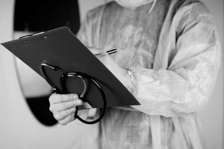 Doctor in blue robe holding a tablet for notes and a stethoscope in the hands ofの写真素材