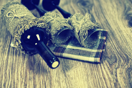 Decorated bottle of fine wine on a wooden table with glassの写真素材