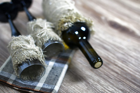 Decorated bottle of fine wine on a wooden table with glassの写真素材