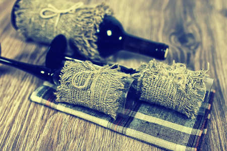 Decorated bottle of fine wine on a wooden table with glassの写真素材