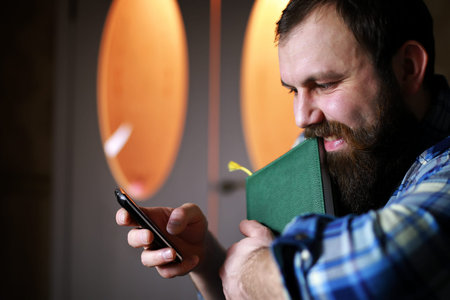 bearded handsome man sitting on a chair and posing for the camera