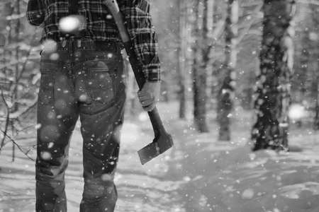 bearded handsome man went into the forest with an ax to produce wood for the furnaceの写真素材
