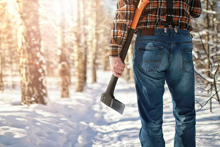 bearded handsome man went into the forest with an ax to produce wood for the furnaceの写真素材