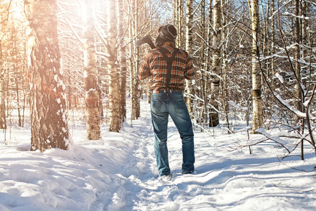 bearded handsome man went into the forest with an ax to produce wood for the furnaceの写真素材