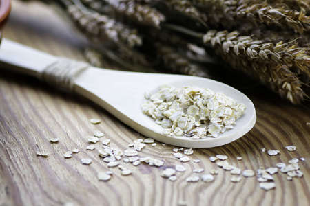 milled wheat in clay pots on a wooden table and a bouquet of dry wheatの写真素材