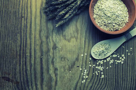 milled wheat in clay pots on a wooden table and a bouquet of dry wheatの写真素材
