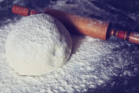 Food crumbly dough from flour on the chef's table with the help of a rolling pin