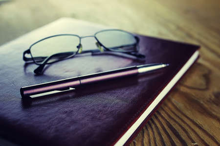 background papers and notebooks on a wooden table bright texturalの写真素材