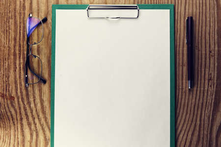 background papers and notebooks on a wooden table bright texturalの写真素材