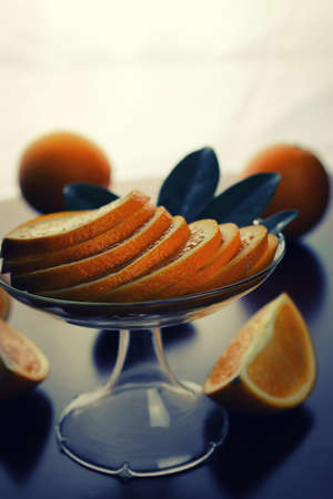 ripe fresh juicy oranges sliced on a glass plateの写真素材