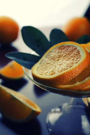 ripe fresh juicy oranges sliced on a glass plateの写真素材