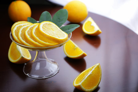 ripe fresh juicy oranges sliced on a glass plateの写真素材