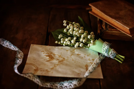 old shabby wooden painted background and a beautiful bouquet of fresh white flowers lily of the valleyの写真素材