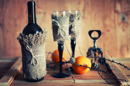 Decorated bottle of fine wine on a wooden table with glassの写真素材