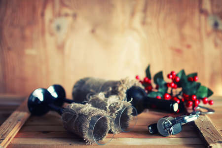 Decorated bottle of fine wine on a wooden table with glassの写真素材