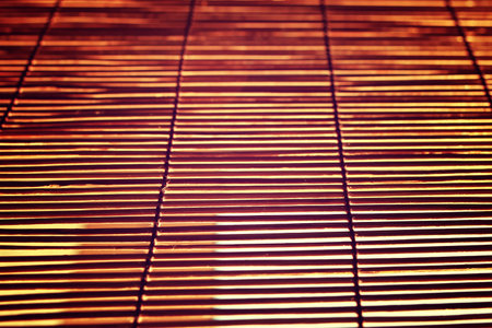 glare from bright sunlight through the wooden Roman Blindsの写真素材