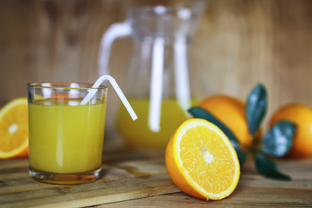 Delicious fresh orange juice on a wooden textural background