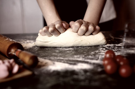 dough for pizza with cherry tomatoes and basil smoked sausage