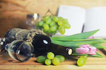 Still on the table a bottle of wine and a bouquet of beautiful pink rosesの写真素材