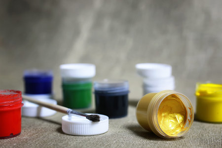 small jars with colorful gouache paints to paint and brush
