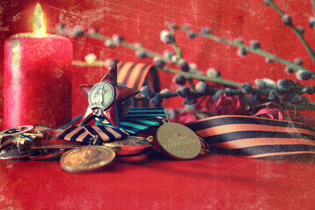 the composition of the old military decorations on a red satin cloth with a branch of a willow