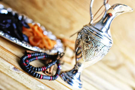 Dried oriental fruit on a silver tray on a wooden table lightの写真素材
