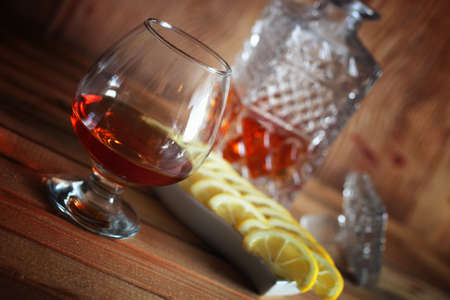 glass with sustained strong alcohol brandy on a wooden tableの写真素材