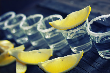 alcohol and lemon slices on  wooden backgroundの写真素材