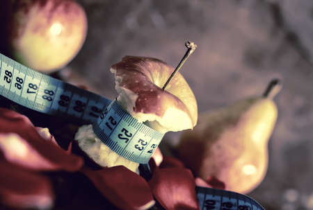 bitten off a little red apple on an old worn wooden backgroundの写真素材