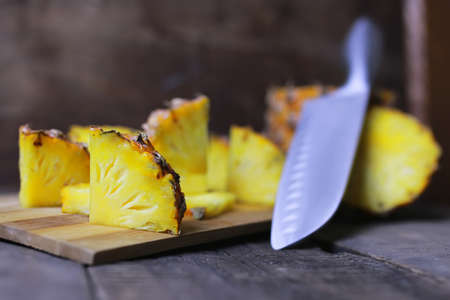 Fresh juicy pineapple on a background of Indian natural texture of wood sheetの写真素材
