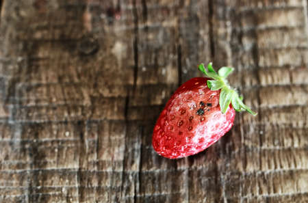 juicy flavorful red ripe strawberry on a wooden natural backgroundの写真素材