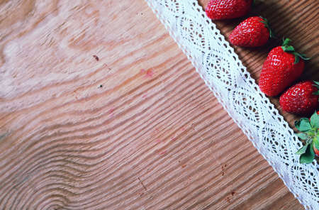 juicy flavorful red ripe strawberry on a wooden natural backgroundの写真素材