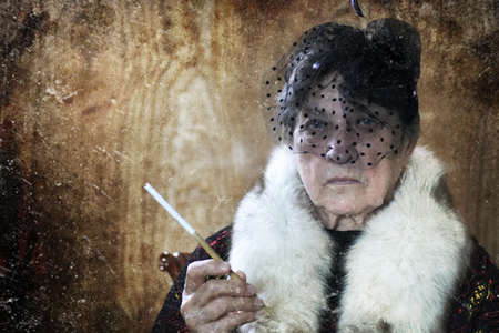 old retirement age woman in a fashionable retro hatの写真素材