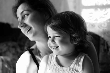 cheerful smiling child in the arms of his mother close-up portraitの写真素材