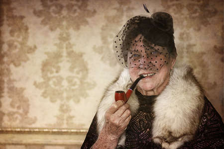 old retirement age woman in a fashionable retro hatの写真素材