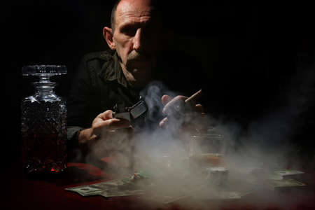 old mustachioed man playing poker at the tableの写真素材
