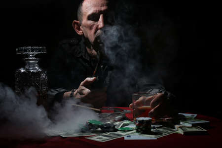 old mustachioed man playing poker at the tableの写真素材