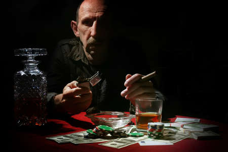 old mustachioed man playing poker at the tableの写真素材