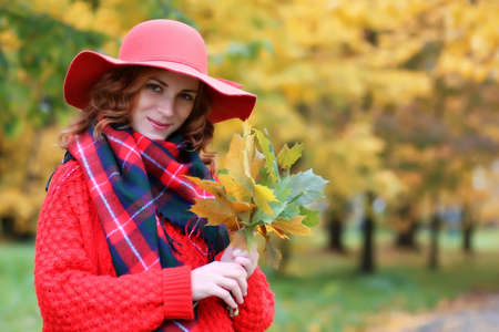 woman wearing red hat in autumn parkの写真素材