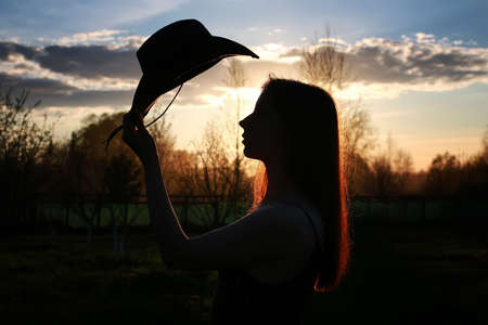 silhouette of young sweet girl  on a warm day in springの写真素材