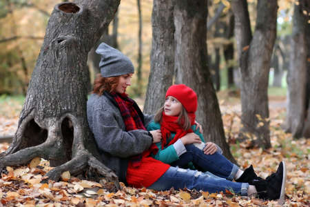 mother and daughter in autumn parkの写真素材