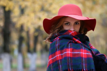 woman wearing red hat in autumn parkの写真素材
