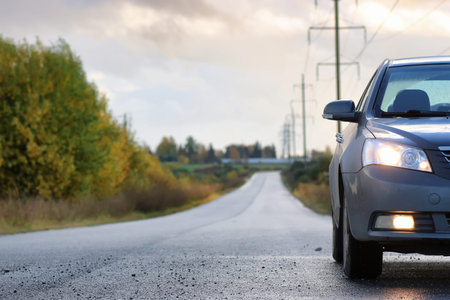 car on country road lane in rainy autumn day