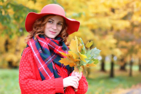 woman wearing red hat in autumn parkの写真素材