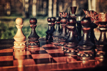 sun glare on the figures in the figures chess board in the park spring evening
