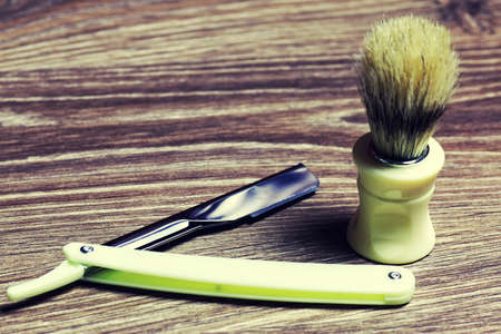 Men's cosmetics shaving brush and razor on a wooden backgroundの写真素材