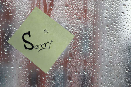 background rain drops on glass and a sticker with the inscription on itの写真素材